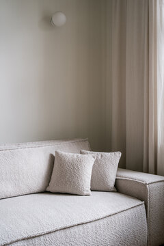 Modern living room with white couch and soft pillows in apartment