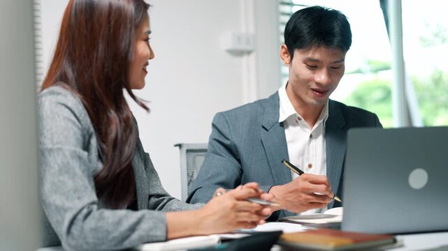 Business Team Discussing Laptop in Modern Office