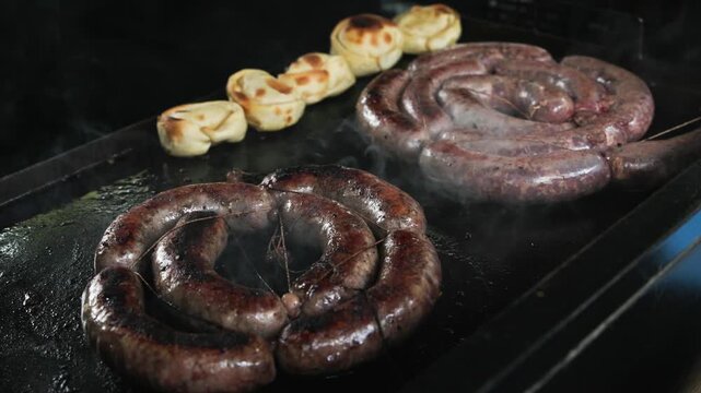 Traditional Colombian blood sausage morcilla with rice and herbs sizzling on hot grill 60fps 4k