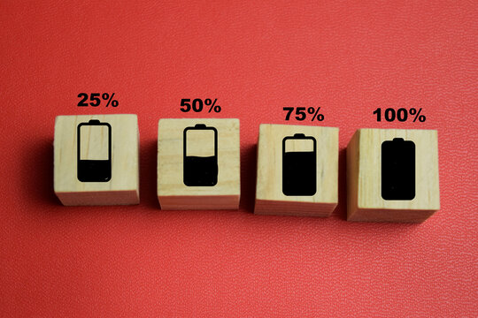 battery charge level indicator with numbered text stacked wooden cubes on the table. For energy status and power capacity
