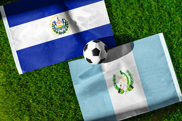 Fototapeta premium El Salvador vs. Guatemala football match. National flags on green grass with soccer ball in the middle. Football background for international match.