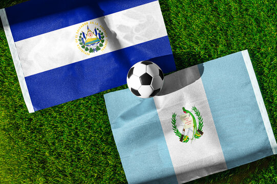 El Salvador vs. Guatemala football match. National flags on green grass with soccer ball in the middle. Football background for international match.