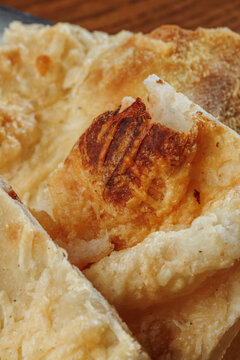 Extreme Close Up of Freshly Baked Italian Flatbread with Melted Cheese, Golden Brown Crust and Crispy Baked Surface