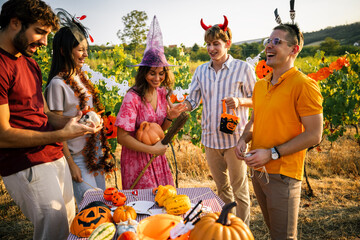 Obraz premium Friends in Halloween costumes sharing laughs and looking at decorations outdoors.