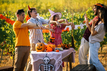 Obraz premium Group of young friends posing like zombies at a Halloween party outdoors in a vineyard.