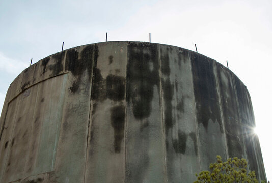 Close up view of a concrete surge tower with water stains at Amadorio dam site under bright sunlight