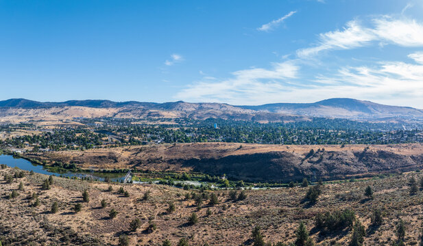 Aerial view of the Klamath River meandering through a dry, vegetated terrain in Klamath County Oregon with rolling hills.