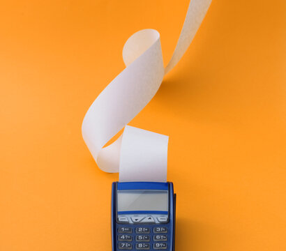 POS Terminal Machine with Long Wavy Receipt on Orange Background