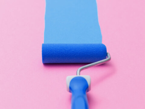 Blue paint roller applying blue stripe on pink wall background