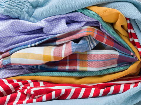 Detailed Side View of Stacked Folded Colorful Clothes