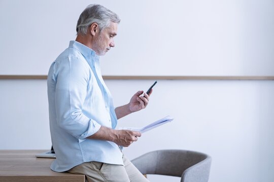 Happy middle-aged business man using smartphone