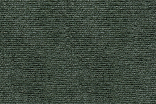 A full-frame, detailed close-up shot of dark green color knitted wool fabric texture. Characteristic horizontal ribbed knit pattern and soft yarn fibers. Top down view