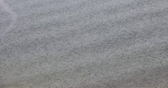 Close-up shot of the sea surface during a severe storm; raindrops falling into the sea.
