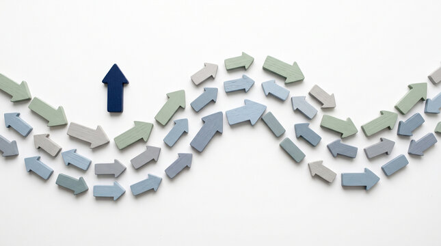 A single dark blue arrow pointing upwards standing out from a group of light blue and green arrows moving in a wave pattern isolated on white background