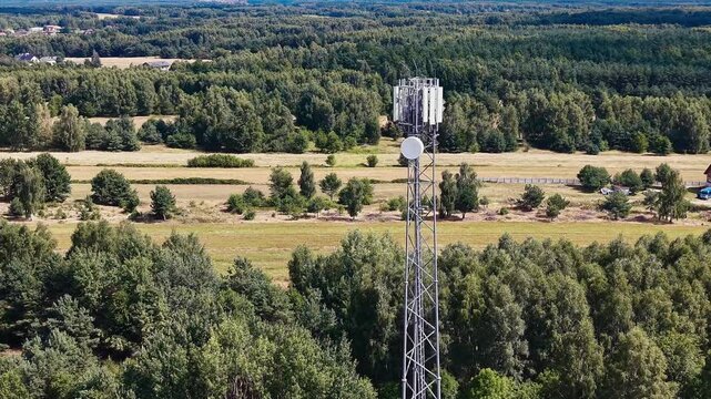 Telecommunications tower in rural landscape at sunset