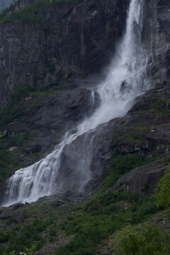 Waterfall cascading down a dark mountain cliff