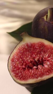 Macro vertical video of sliced fresh fig fruit with moving sunlight shadows