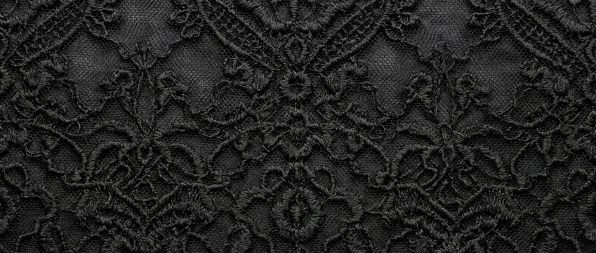 Intricate black lace fabric texture. Dark gothic floral pattern on sheer mesh background. Elegant vintage textile macro photography