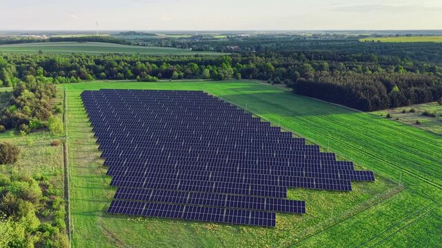Aerial view of solar panel farm in green rural landscape