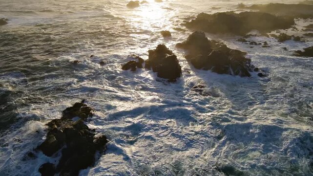 Aerial shot of the rugged coastline covered in fog at dawn along the Pacific Ocean south of Monterey California