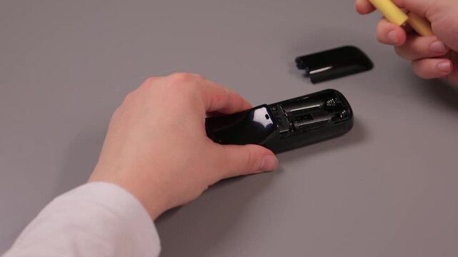 Instructional process of replacing battery in small electronic device. Comprehensive tutorial on inserting and securing battery within electronic device enclosure