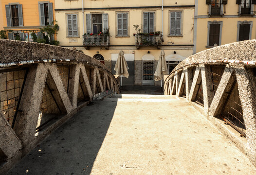 In the foreground, we cross an old stone bridge over Milan&rsquo;s canal