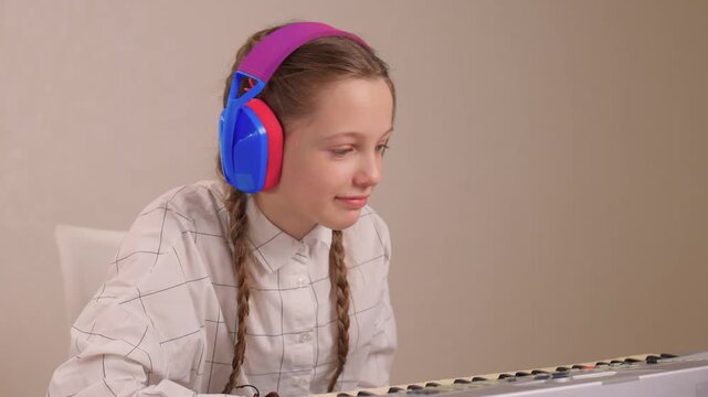 Young female musician rehearsing melodies on digital piano at home. Brightly lit scene of youthful girl honing musical skills on electronic keyboard in cozy environment