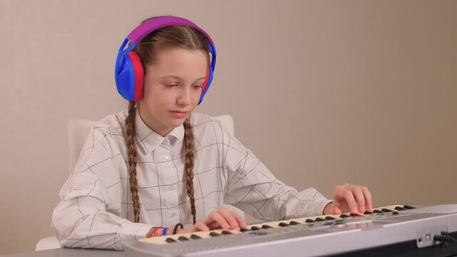 Young female musician rehearsing melodies on digital piano at home. Brightly lit scene of youthful girl honing musical skills on electronic keyboard in cozy environment