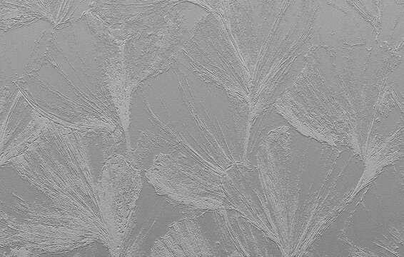 Grey stucco wall background with floral relief pattern.