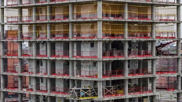 Helsinki, Finland - 26 August 2022: View of the Kalasatama high rise construction site with workers on platforms and concrete pillars. Timelapse.