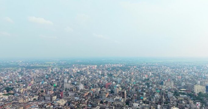 Wide panoramic aerial view of a densely populated urban city skyline with numerous residential buildings under a hazy sky