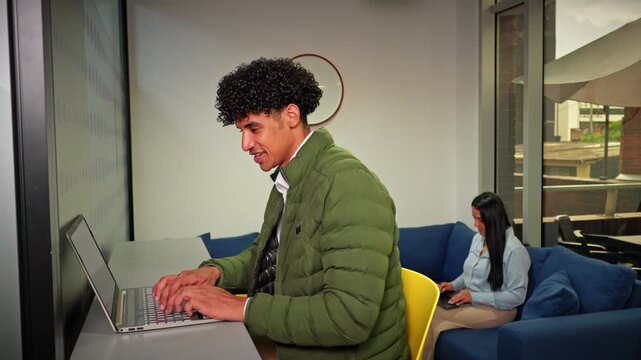 Young Professional Working On A Laptop In A Modern Coworking Space