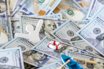 Financial crisis survival and debt relief concept. Little wooden person falling overboard into...
