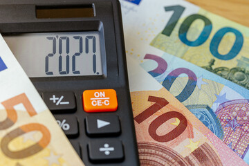 Naklejka na ściany i meble Euro currency in 2027 year. Financial business concept. Money and calculator with date 2027. Market analysis Eurozone. exchange rate. Economic background. closeup
