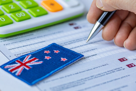 New Zealand tax return. NZ financial form. Calculator and pen. Filing taxes concept. Accounting paperwork.