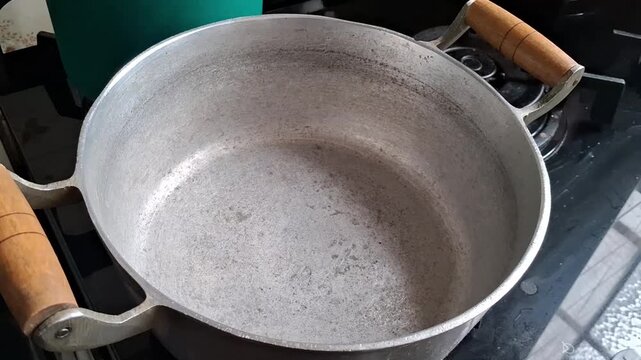 Empty aluminum cooking pot resting on stove top