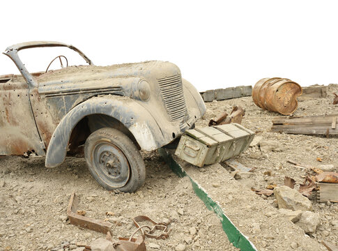 Isolated vintage military car stands by wooden ammo box and rusty barrel over blank white background. Minimalist historical warfare cutout scene