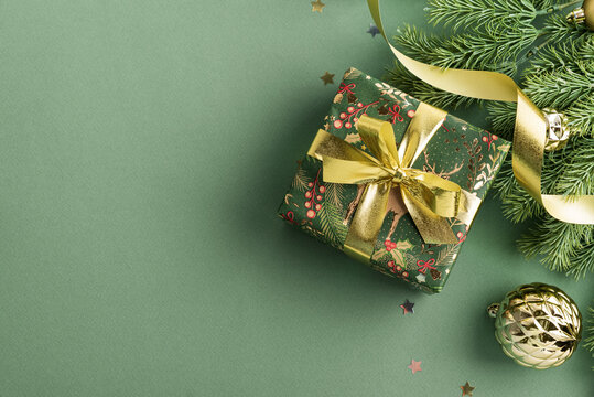 Festive Holiday Gift Box with Pine Branches and Golden Ribbon Decoration