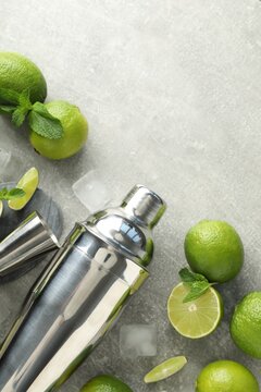 Ingredients for mojito, shaker and jigger on light grey table, flat lay