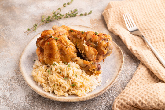 Fried Turkey Wing with spices and rice on brown concrete, side view, close up