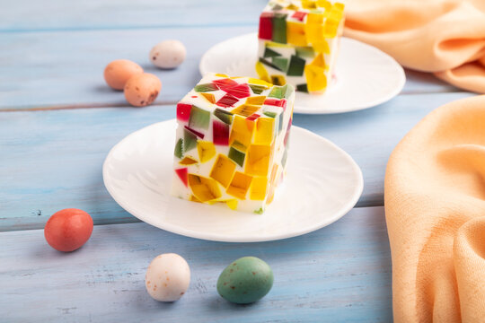 Colored Fruit and milk jelly on blue wooden, side view, close up