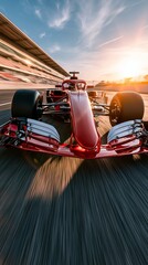 Obraz premium A red Formula 1 race car speeding on a track at sunset, dynamic motion blur, vibrant colors, high-speed racing action, sleek design, professional motorsport.