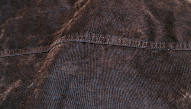 Dark washed denim fabric texture with stitching