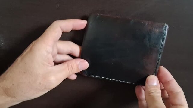 Leather wallet inspection showing quality stitching