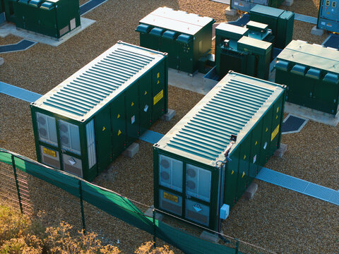 Aerial view of Battery Energy park, BESS Grendon, featuring large green energy storage containers arranged on a gravel site with security fencing, Northampton, England, United Kingdom.