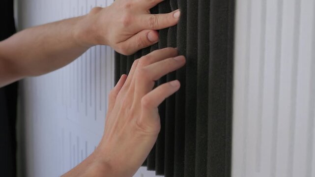 Ensuring proper foam placement and pressure for soundproofing quality. Positioning and inspecting foam wedges against panels for optimal acoustic sealing and finishing