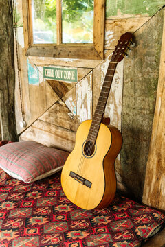 Cozy chill out zone with acoustic guitar, cushion, and rustic wooden wall