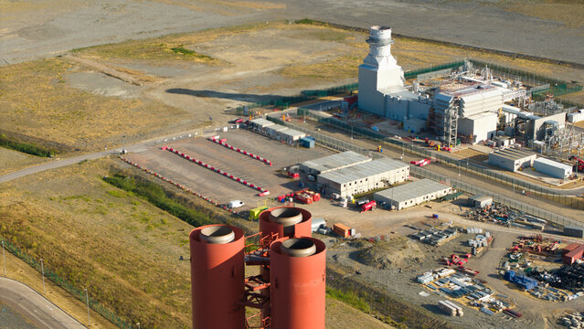 Aerial view of Millbrook Power Plant featuring large red chimneys and industrial infrastructure surrounded by open land in Stewartby, England, United Kingdom.