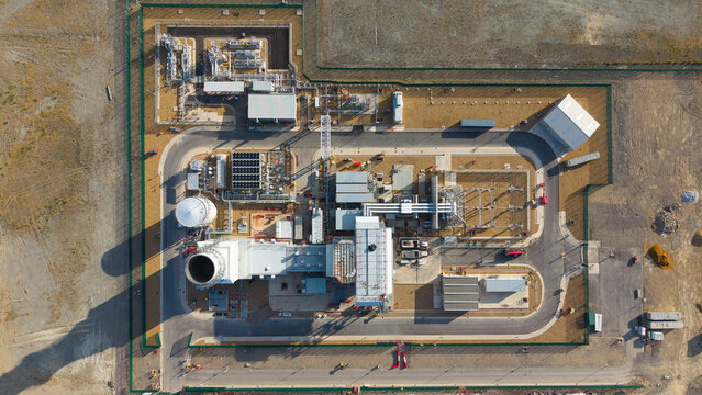 Aerial view of Millbrook Power Plant featuring industrial infrastructure, storage tanks, power units, and paved roads within a fenced facility in Stewartby, England, United Kingdom.