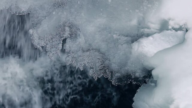 Ice crystals edge rushing dark water. Closeup frosty shoreline winter stream.